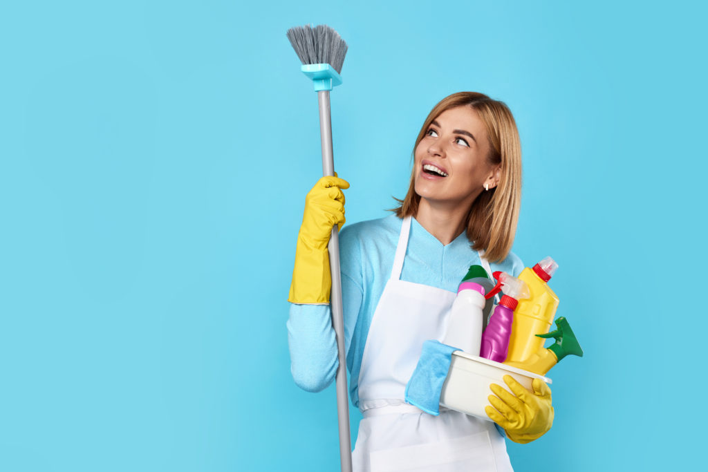 woman in gloves holding bucket of detergents and broom
